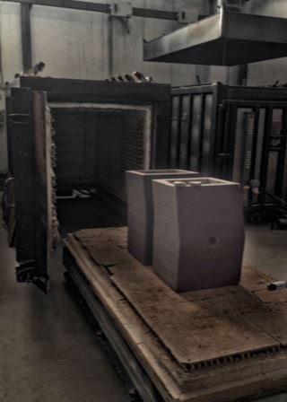 Newly shaped lava stone sinks inside an industrial kiln during the production process