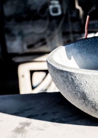 Close-up of a lava stone sink with a raw finish, captured during the manufacturing process